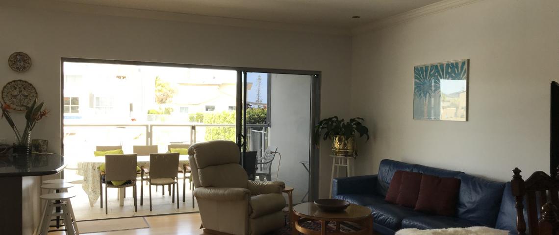 This looks out through the lounge to the balcony where the outdoor dining is, along with a barbecue.
